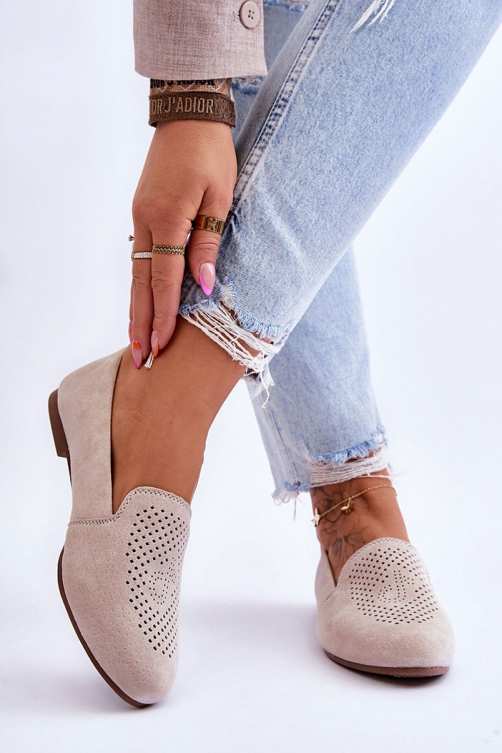 Luxury women's suede moccasins with decorative openwork design, showcasing comfort insole and flat heel, modeled by a fashion-forward individual in stylish denim.