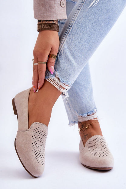 Luxury women's suede moccasins with decorative openwork design, showcasing comfort insole and flat heel, modeled by a fashion-forward individual in stylish denim.