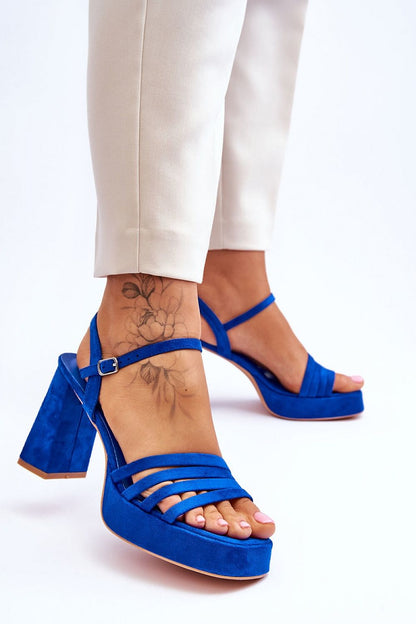 Chic blue platform heel sandals with adjustable ankle strap, styled elegantly with tailored trousers, exclusively from Step in Style.