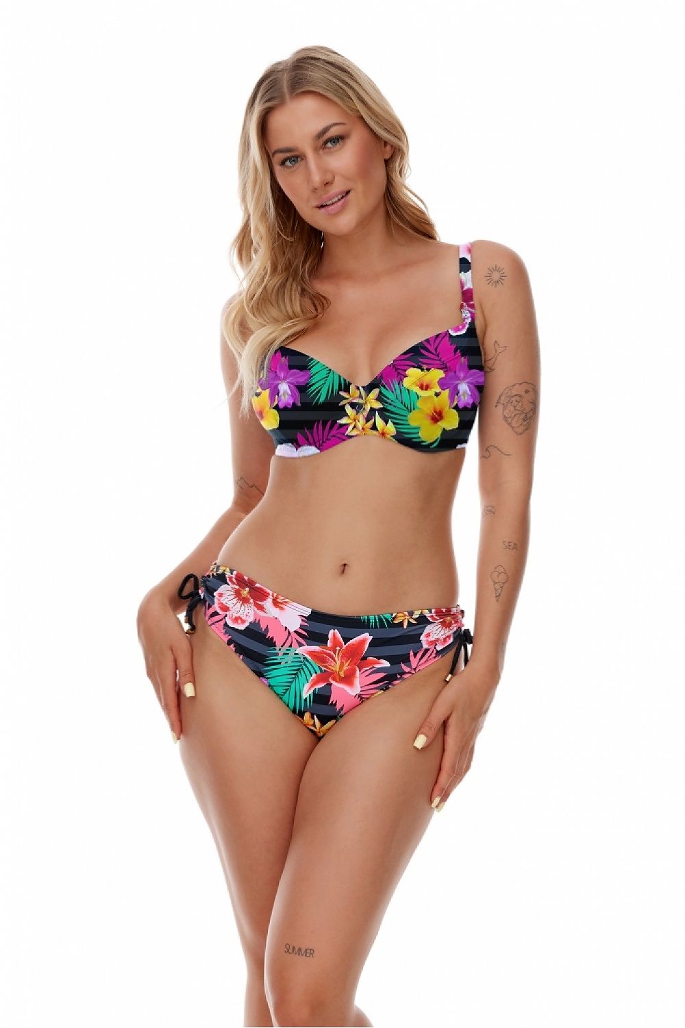 Elegant model showcasing the Lupo Line Exotic Floral Swimming Bra with Underwire Support, featuring vibrant floral designs against dark stripes, perfect for enhancing medium to large busts.