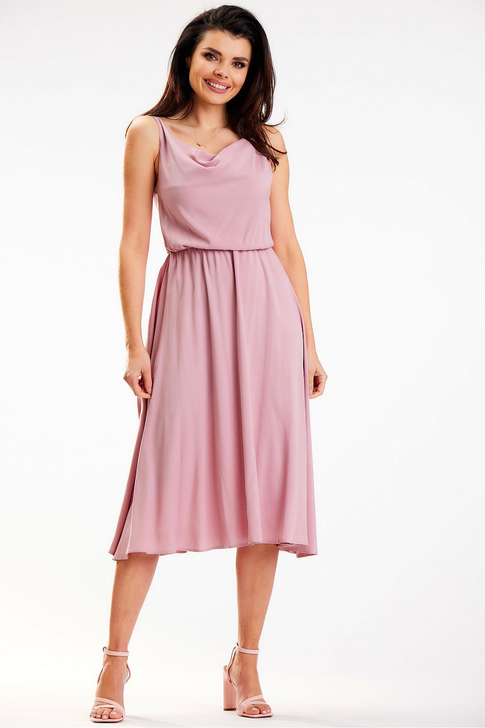 Elegant Awama midi dress in soft pink, featuring a crinkled neckline and an elastic waistband, perfectly flattering the figure, displayed by a smiling model in an elegant pose.