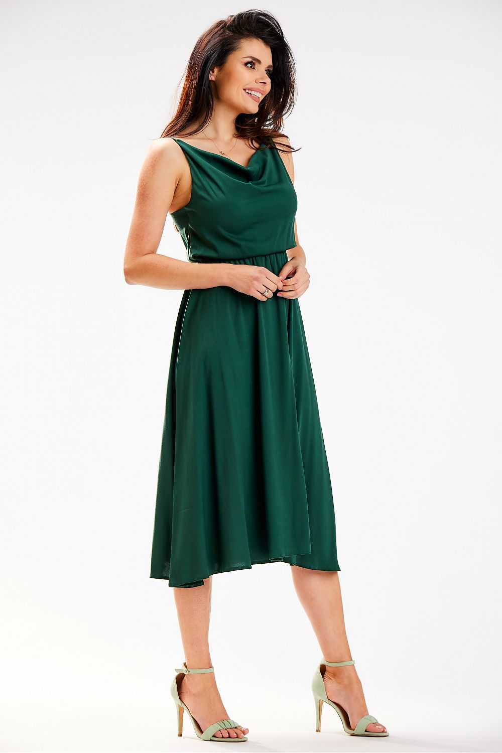 Chic Awama midi dress in rich green, designed with a stylish cowl neckline and elastic waist, captured in a graceful pose from the side.