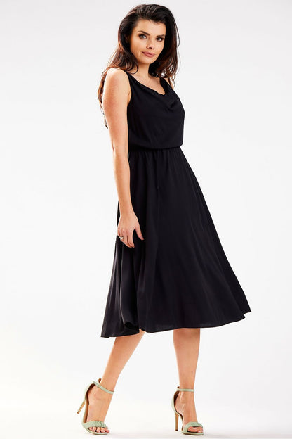 Sophisticated Awama midi dress in black, displaying a crinkled neckline and flattering fit, styled with fashionable heels for a luxurious look.