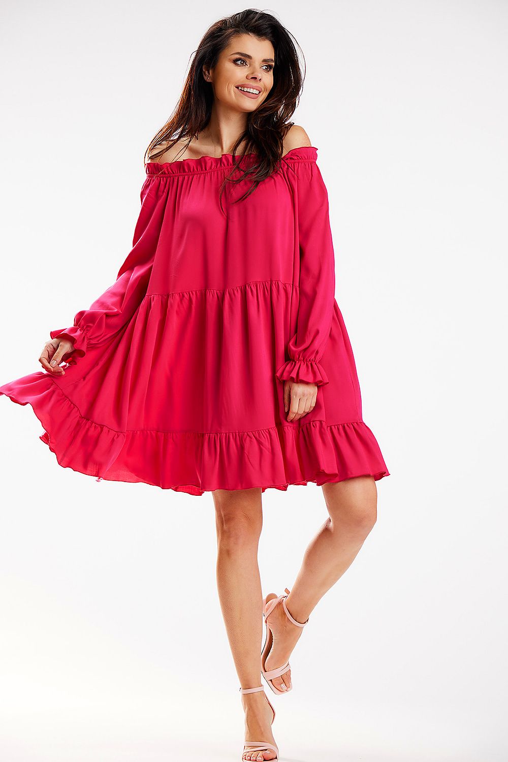 A radiant Awama Spanish A-Line dress in vibrant pink, displayed in a playful pose, showcasing its flattering silhouette and luxurious fabric, suitable for both casual and upscale outings.