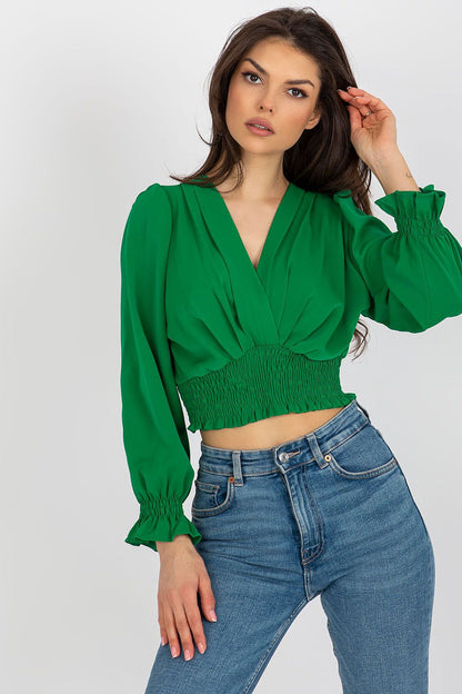 Fashionable model presenting a chic long sleeve green blouse with envelope neckline and gathered hem, paired with denim, created by Italy Moda.