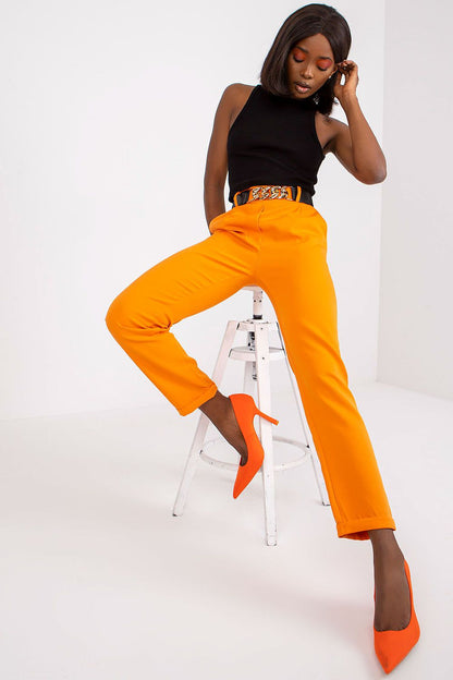 Sophisticated orange high rise trousers paired with a statement belt, perfect for date night and fashionable outings, by Italy Moda.
