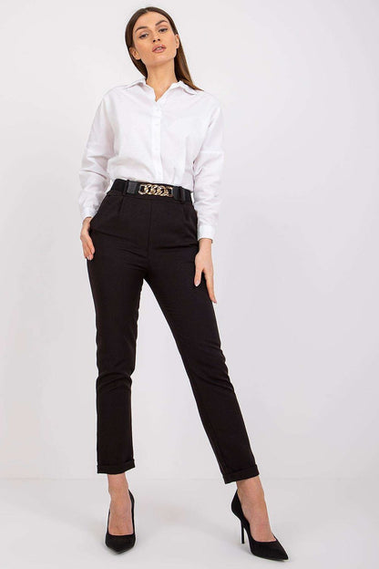 Fashionable woman in luxury women's black high rise trousers by Italy Moda, elegantly dressed in a classic white shirt for a sophisticated look.
