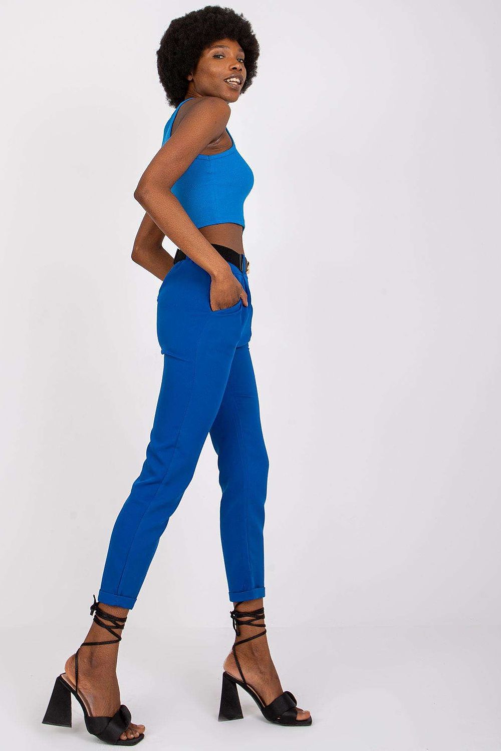 Side angle of a model wearing Luxury Women’s High Rise Trousers by Italy Moda, accentuating the tailored fit and stylish pockets, complemented by a blue crop top.