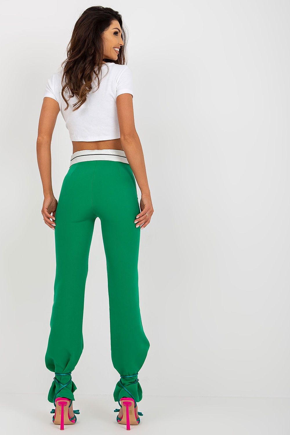 Elegant back view of Italy Moda Women's High-Waisted Straight Cut Trousers in vibrant green, styled with a chic white cropped top and eye-catching heels.