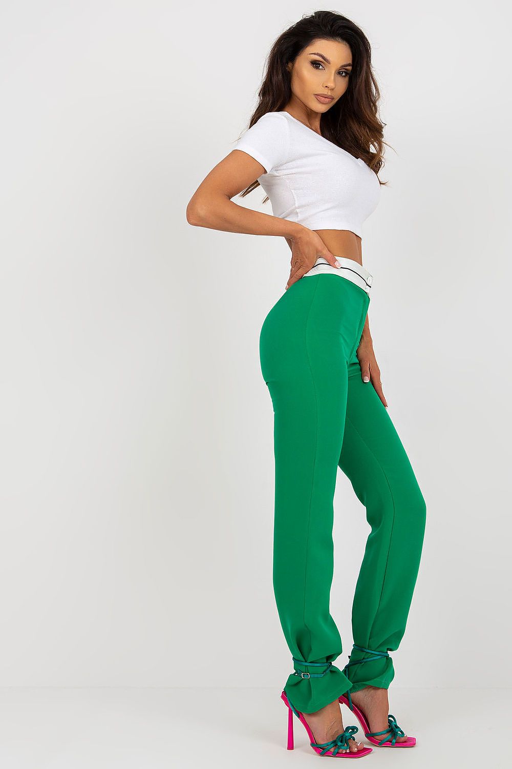 Stylish side profile of Italy Moda Women's High-Waisted Straight Cut Trousers in green, paired with a white cropped top and statement heels for a sophisticated look.