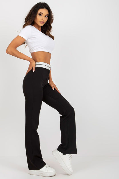 Elevate your style with Italy Moda women's high-waisted straight cut trousers, featuring a sophisticated black design and paired with a chic cropped white top, showcasing an elegant and modern fashion statement.