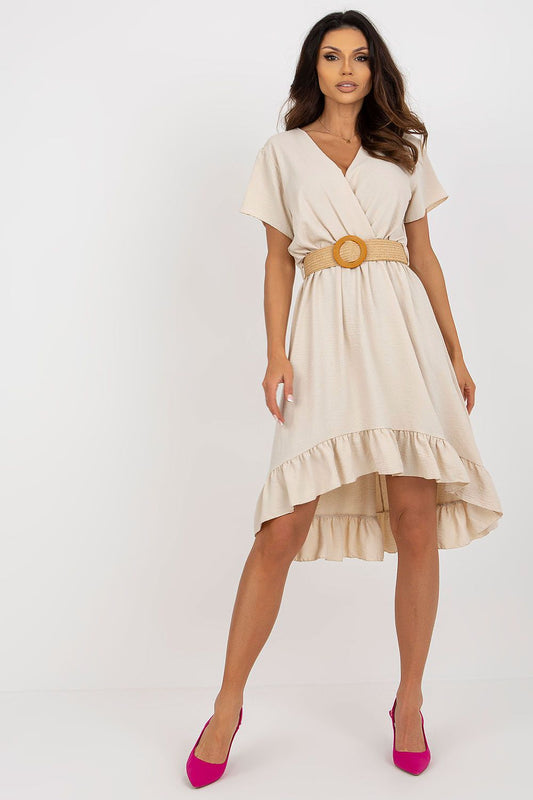 Elegant asymmetrical summer dress with decorative frill and braided belt from Italy Moda, showcased in a light beige colour, perfect for warm weather occasions. Model wears pink heels to enhance the luxurious look.