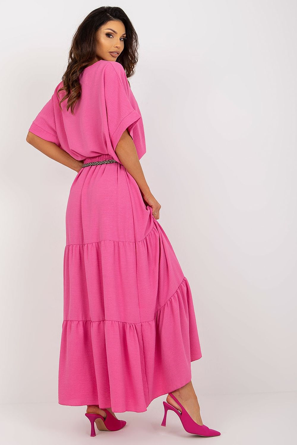A luxurious long summer skirt in vibrant pink with decorative frills and a matching belt, captured from the back. Styled by Italy Moda, this elegant piece embodies sophistication and high fashion, perfect for summer occasions.