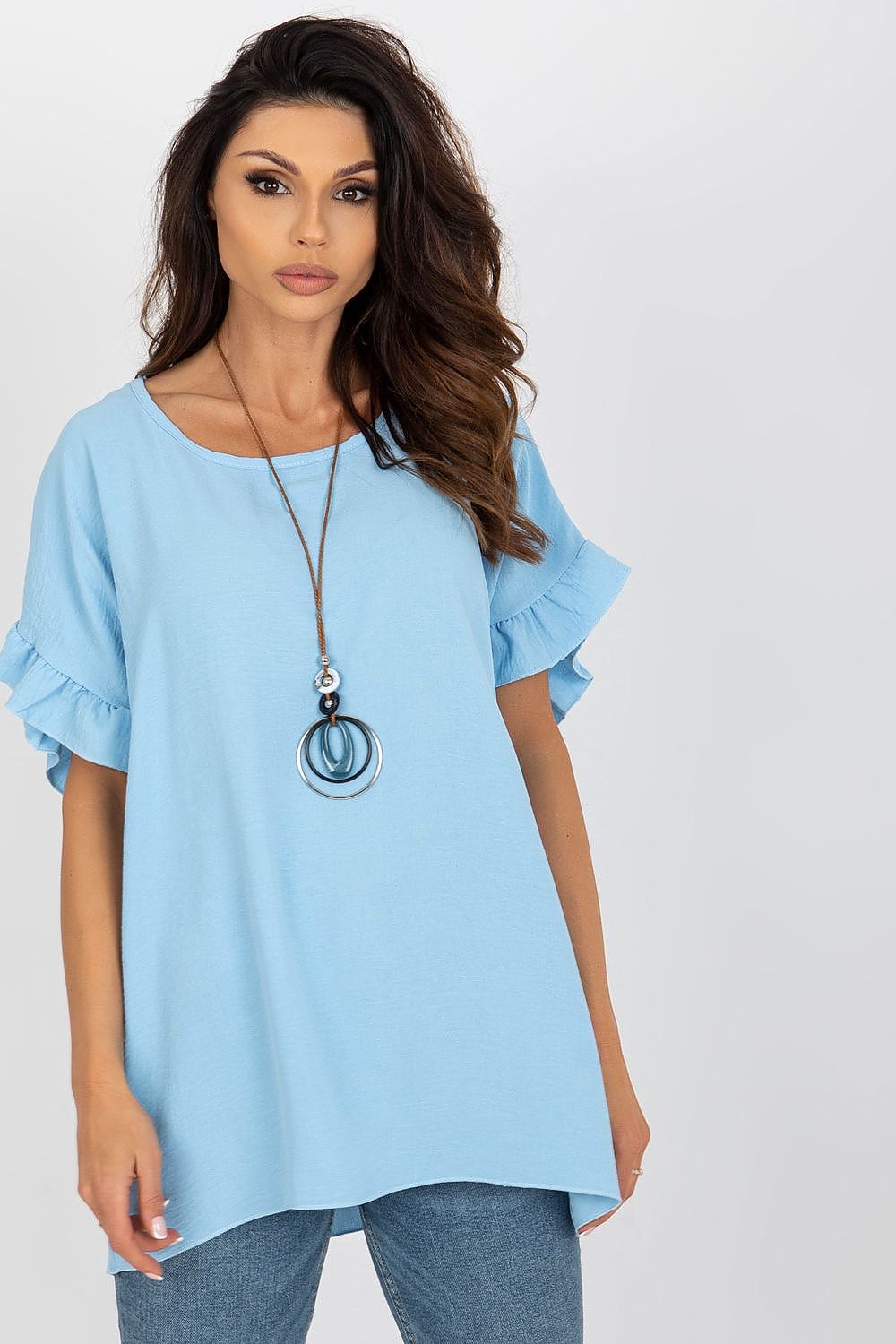 Italy Moda loose-fit blouse in soft blue, featuring elegant frill sleeves and a round neckline, styled with a chic statement necklace.