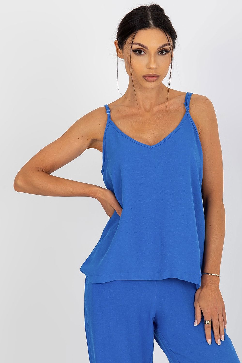 Och Bella luxury loose-fitting v-neck shirt in vibrant blue, featuring adjustable straps, expertly styled on a model with a sophisticated expression.