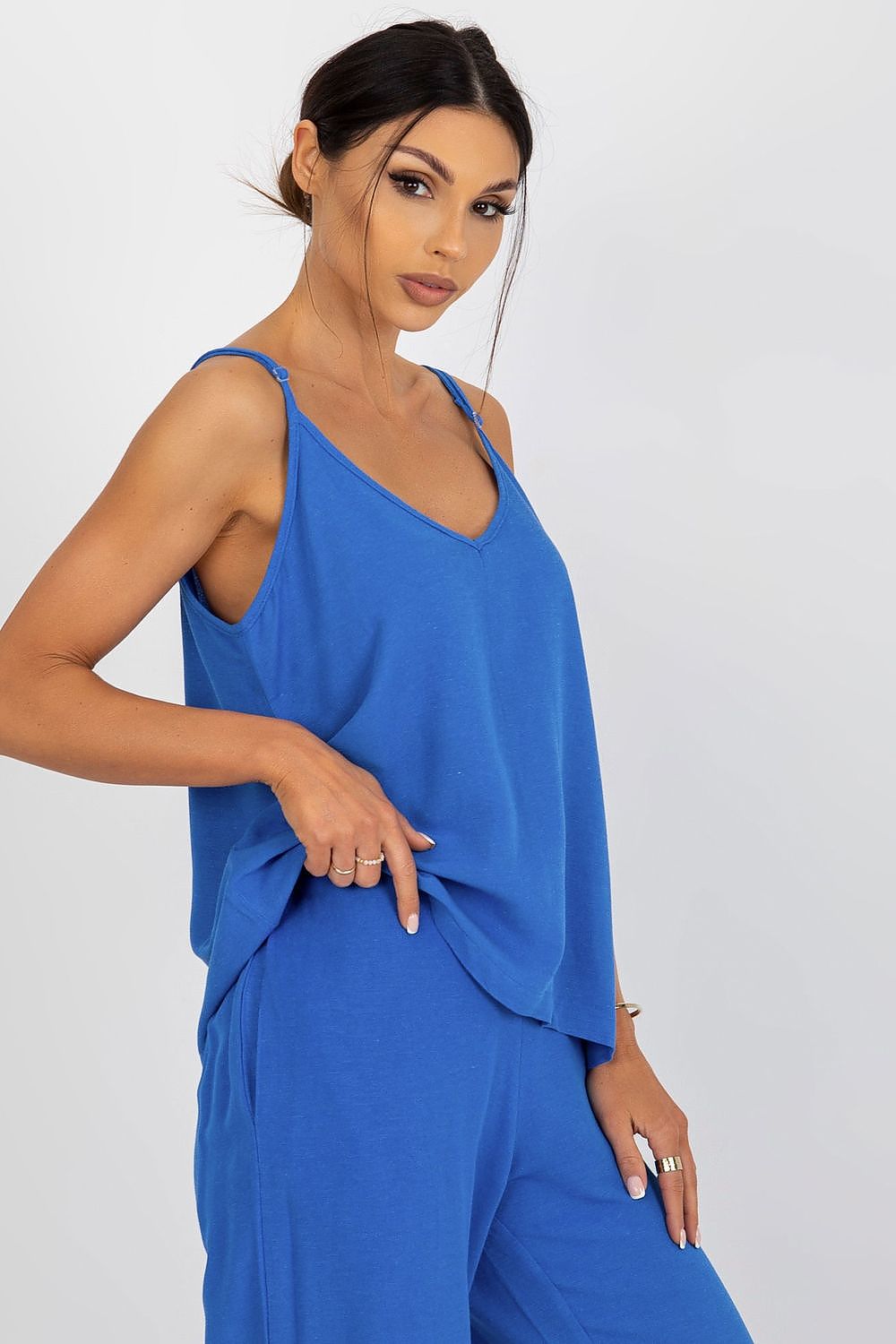 Side view of the Och Bella blue loose-fitting shirt with adjustable straps, showcasing its elegant flow worn by a chic model.