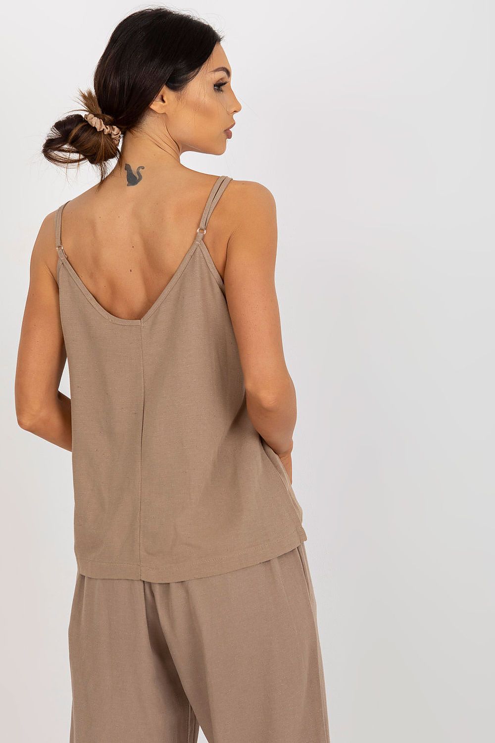 Elegant woman showcasing the Och Bella Loose-Fitting V-Neck Shirt with adjustable straps in a soft neutral tone, perfect for a luxurious, relaxed outfit.