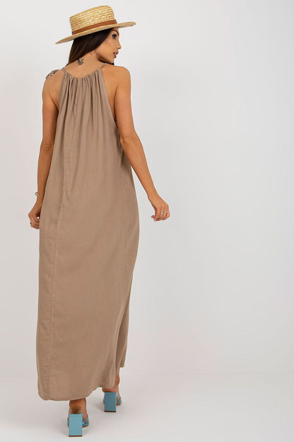 Back view of the luxurious Och Bella summer long dress with a flowing silhouette, highlighting the tied straps and relaxed fit, paired with elegant footwear.