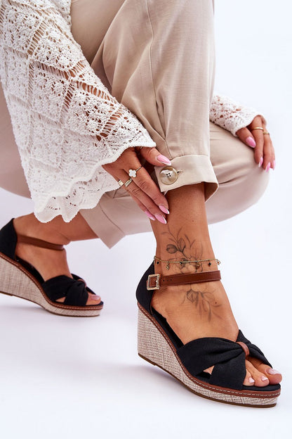 Luxurious women's sandals from Step in Style with a stylish knotted design, showcased with a lace top and tailored trousers, perfect for summer occasions.