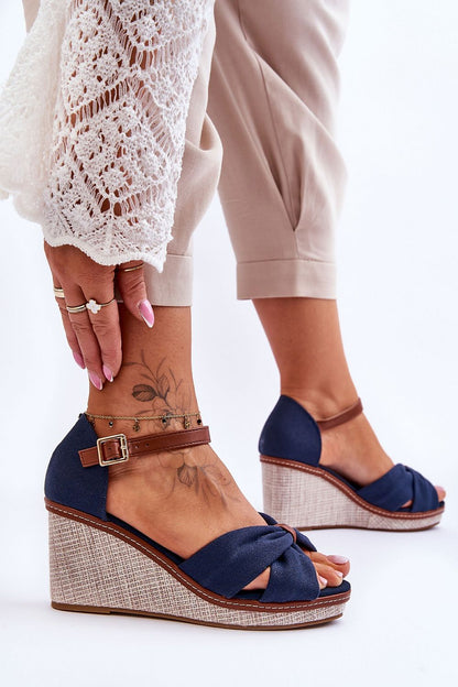 Refined women's sandals by Step in Style in navy, featuring a 8cm wedge heel and knotted detailing, showcased with intricate jewellery and airy summer attire.