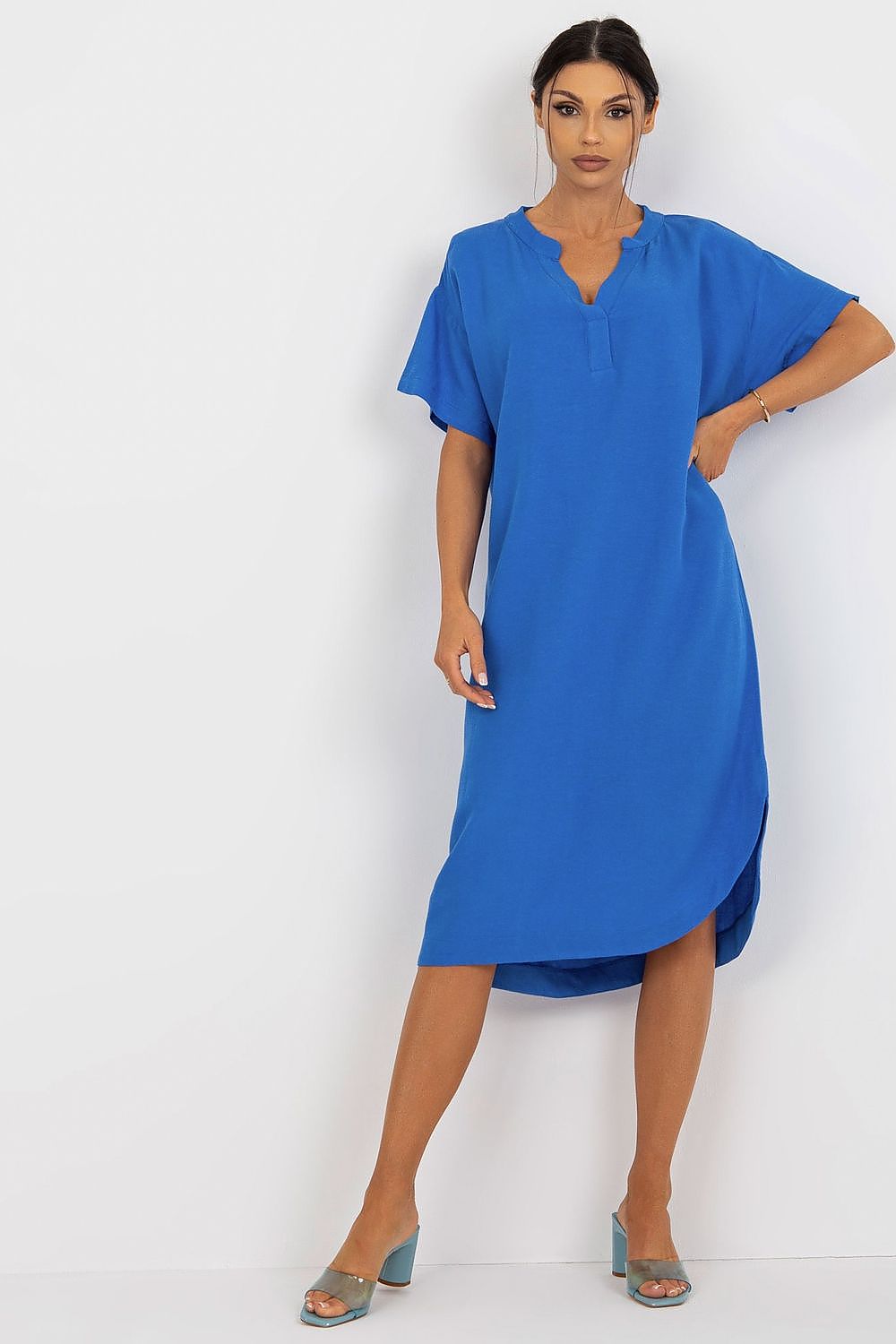 Vibrant blue Och Bella shirt dress with heart neckline and side slit, exuding luxury in its cotton, linen, and viscose blend. Model stands confidently, highlighting the dress's stunning colour.
