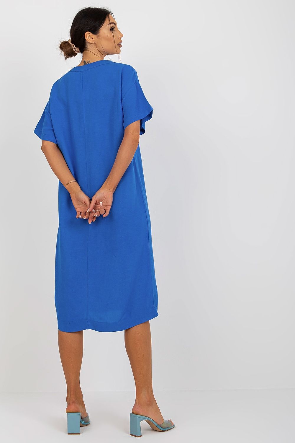 Back view of a luxurious blue Och Bella shirt dress featuring a heart neckline. Crafted from a fine cotton, linen, and viscose blend, the model showcases the timeless elegance of the design.