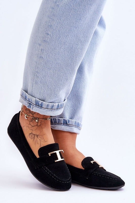 Elegant women's classic slip-on moccasins from Step in Style, featuring a decorative strap, showcased with stylish denim and delicate ankle tattoo.