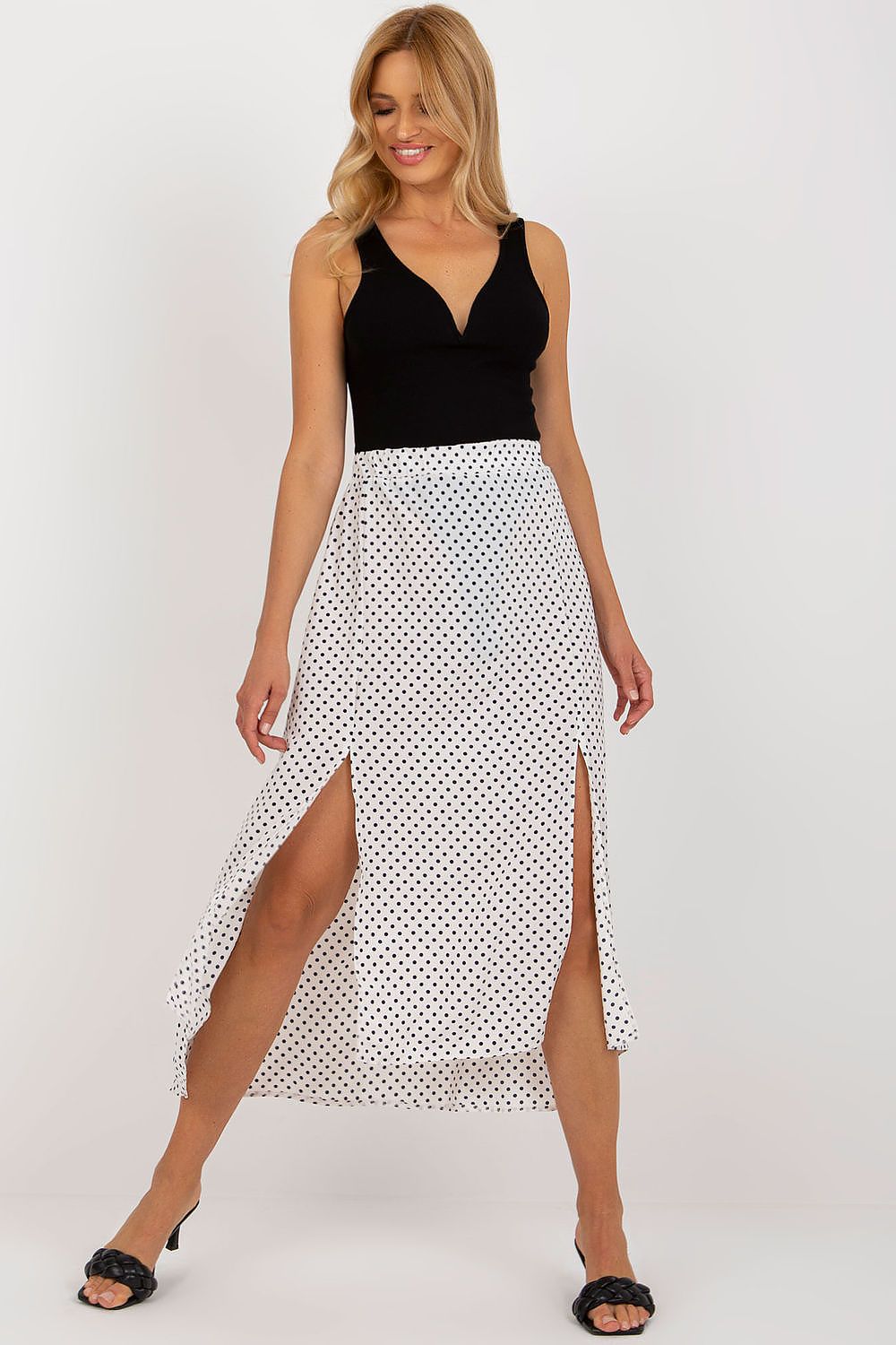 Chic detail view of the Rue Paris asymmetrical long skirt showcasing its exquisite navy polka dot pattern and stylish front slits.