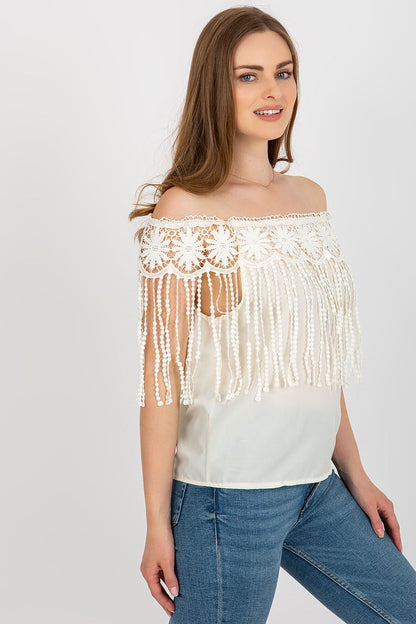 Elegant summer blouse by AT featuring a Spanish-style neckline and intricate lace trim, perfect for luxurious seasonal fashion.