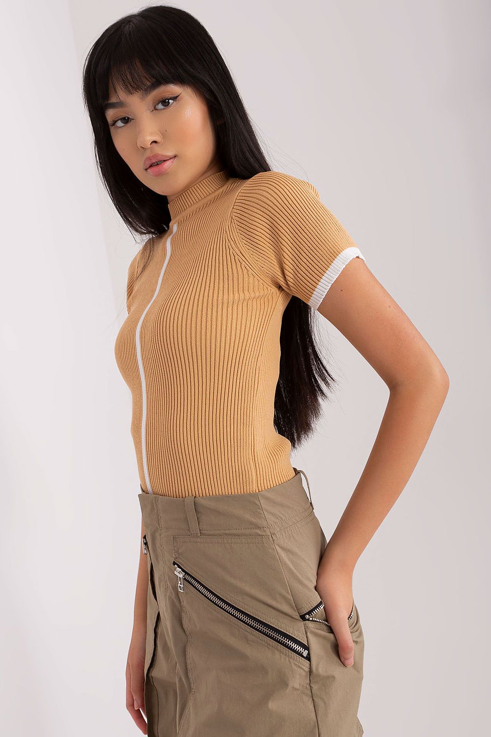 Model wearing the luxurious Badu ribbed blouse with short sleeves and half turtleneck, demonstrating its versatile styling options.