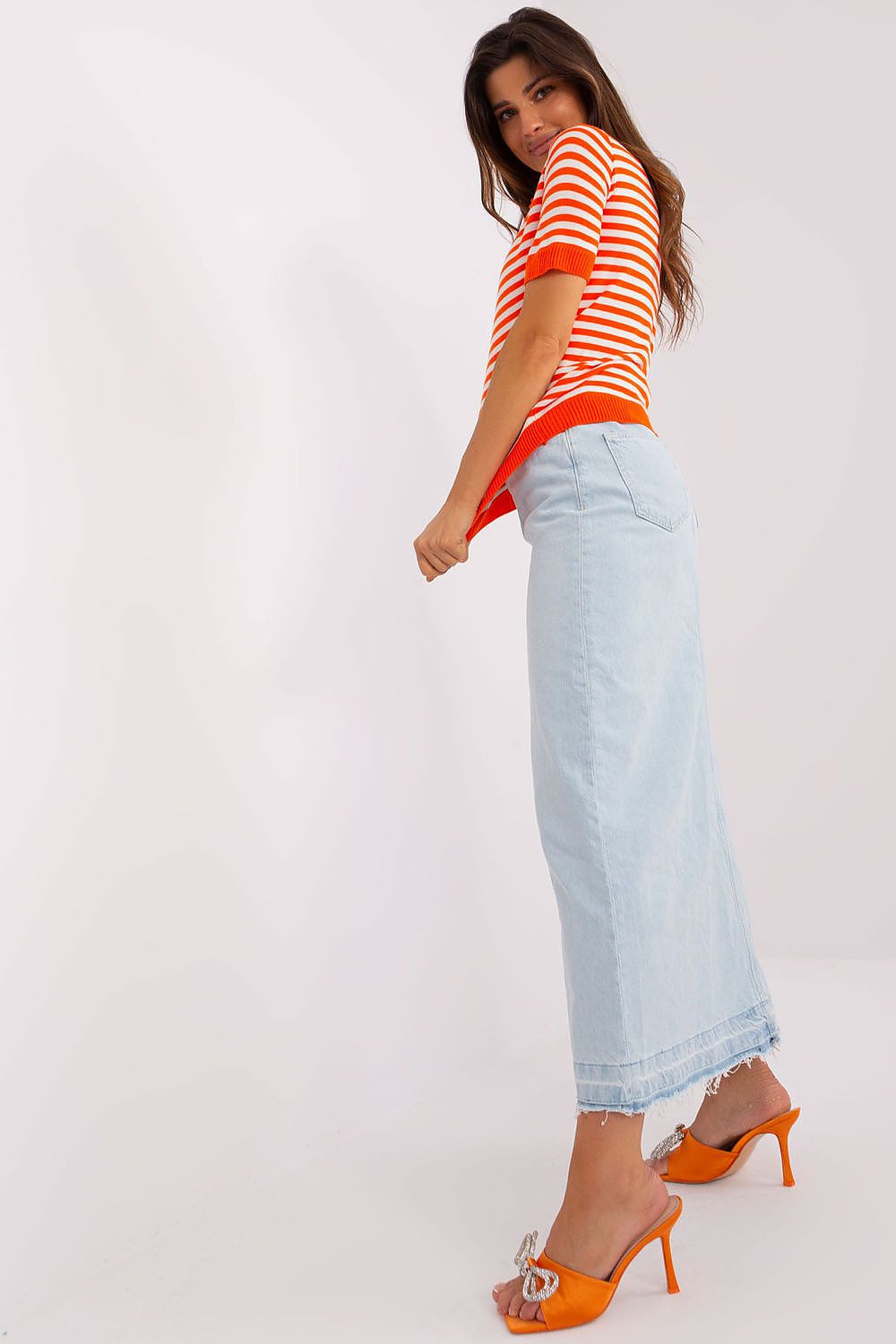 Side view of Badu's short-sleeved luxury knitted blouse with collar, accentuating its tailored fit and stylish stripes.