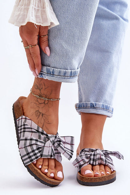 Elegant cork sole flip-flops featuring an eco-suede footbed and a charming bow, perfect for luxury summer fashion by Step in Style.