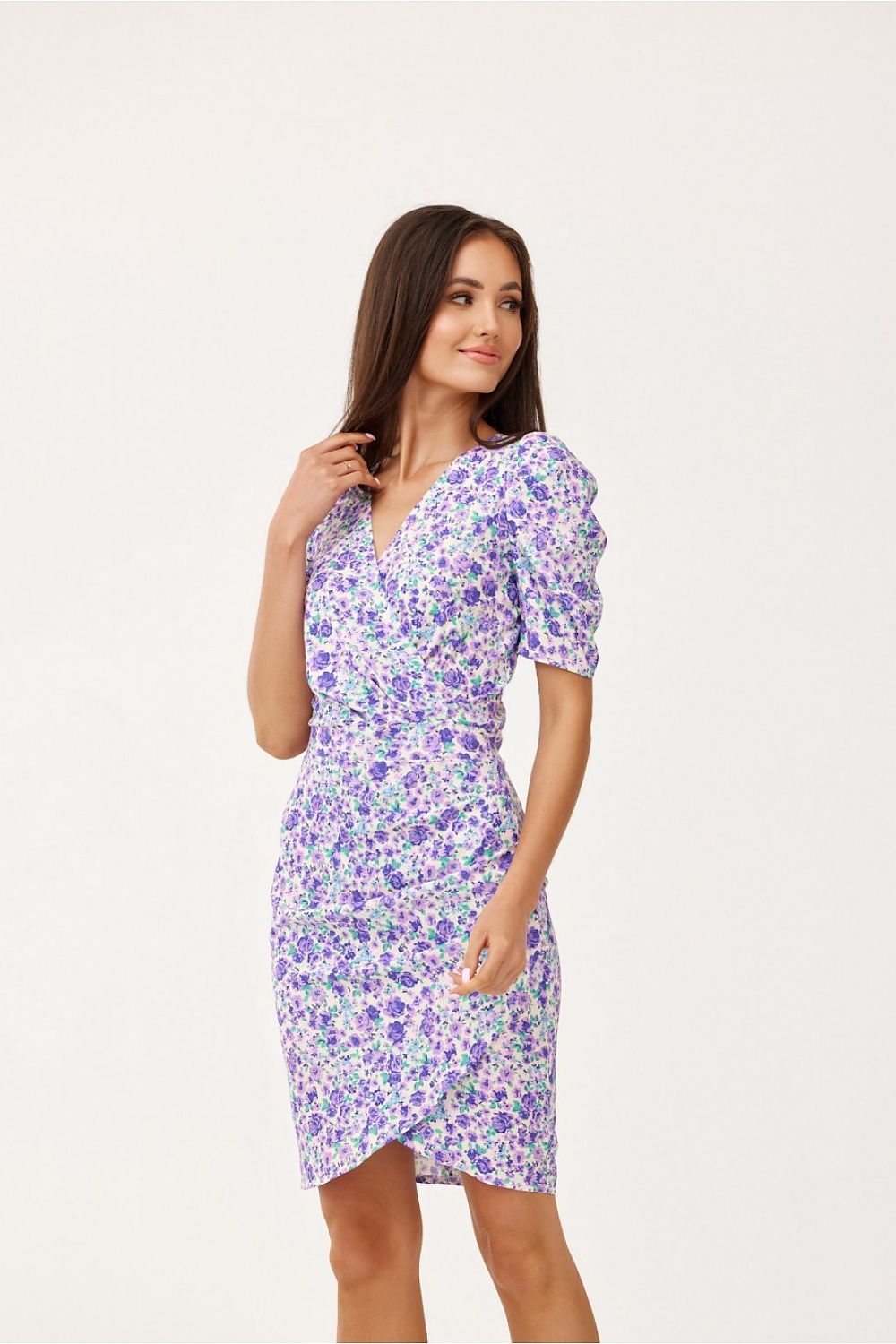 Model wearing a luxurious mini dress by Roco Fashion with an envelope neckline and ruffled sleeves, styled with elegant accessories for a complete look.