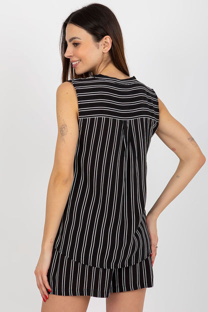 Fashion model wearing Fresh Made sleeveless patterned blouse, exuding elegance and charm.