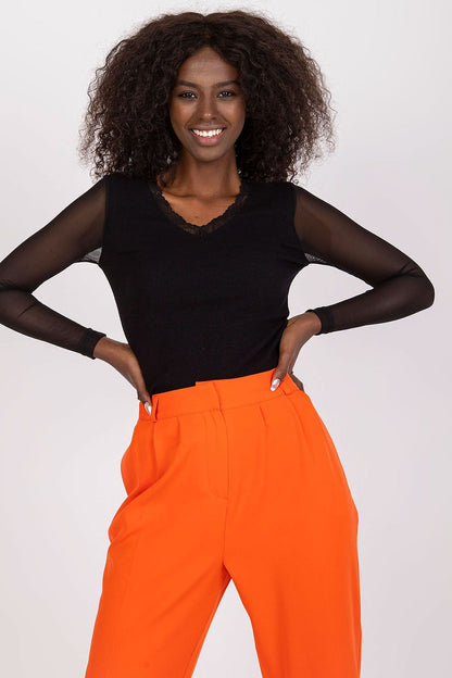 Fashion model wearing the Rue Paris trendy ribbed blouse with intricate transparent sleeve detailing.