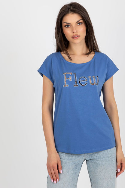 Chic blue women's t-shirt by Fancy, artistically adorned with a decorative cut-out inscription 'Flew'. Model displays the relaxed fit and luxurious fabric in a striking pose.