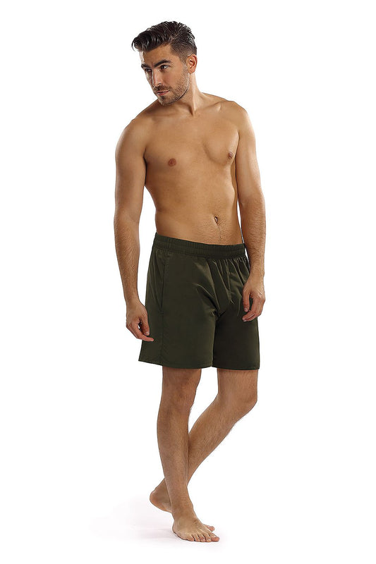 Luxury Lorin Swimming Trunks in deep green, showcased on a shirtless model, highlighting the soft polyamide fabric and adjustable elastic waistband, perfect for poolside elegance.