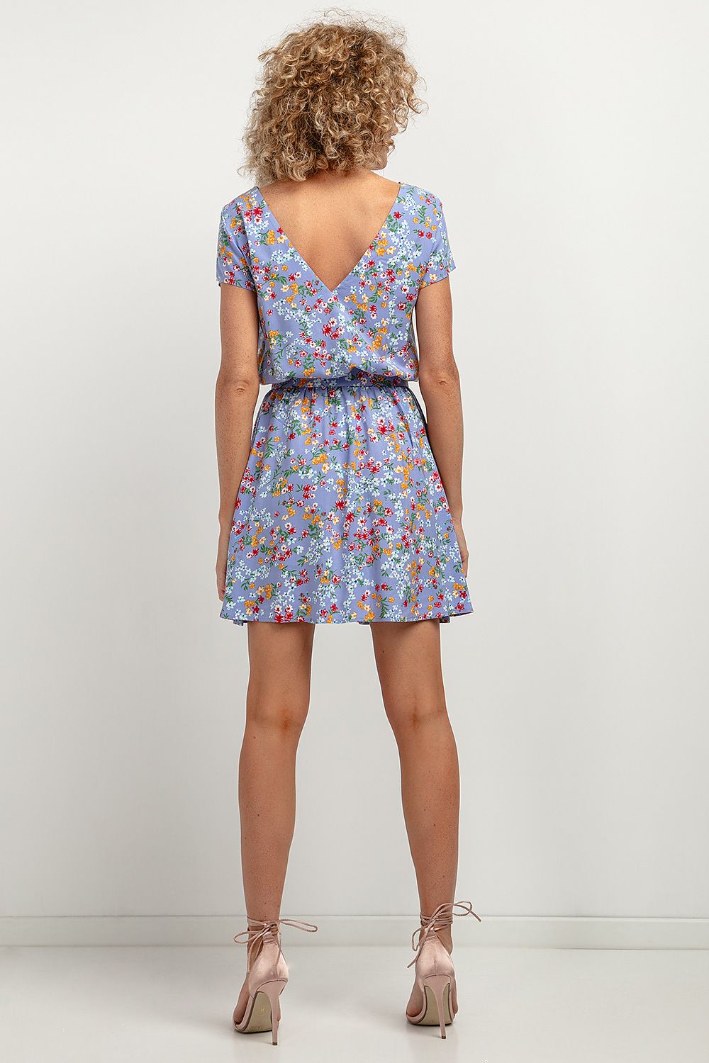 Model wearing the Tessita Elegant Floral Daydress, highlighting the deep V-neck back and tied waist belt for a flattering silhouette.