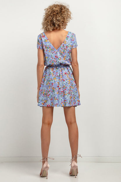 Model wearing the Tessita Elegant Floral Daydress, highlighting the deep V-neck back and tied waist belt for a flattering silhouette.