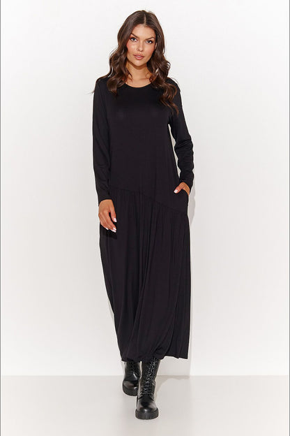 Luxurious Numinou Maxi Dress in Graphite Melange, featuring airy viscose knit fabric, round neckline, long sleeves, asymmetrical stitching, and slip pockets, perfect for sophisticated occasions.