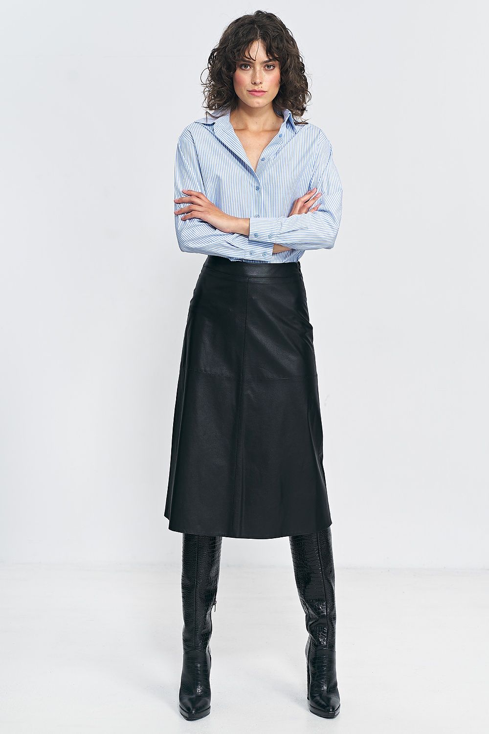 Luxurious Nife imitation leather skirt styled for autumn with chic boots, enhancing the silhouette.