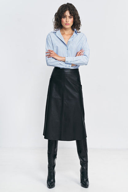 Luxurious Nife imitation leather skirt styled for autumn with chic boots, enhancing the silhouette.