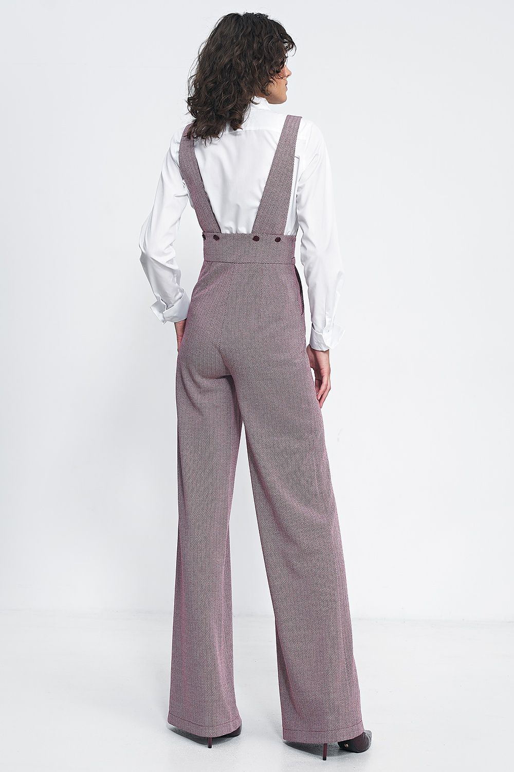 Stylish model wearing Nife's vintage-inspired high-waisted jumpsuit with wide legs and functional pockets, ideal for sophisticated casual wear.