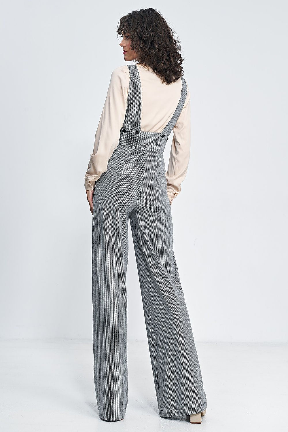 Stylish Nife high-waisted jumpsuit showcased on a model, displaying its luxurious wide leg design and chic suspenders.
