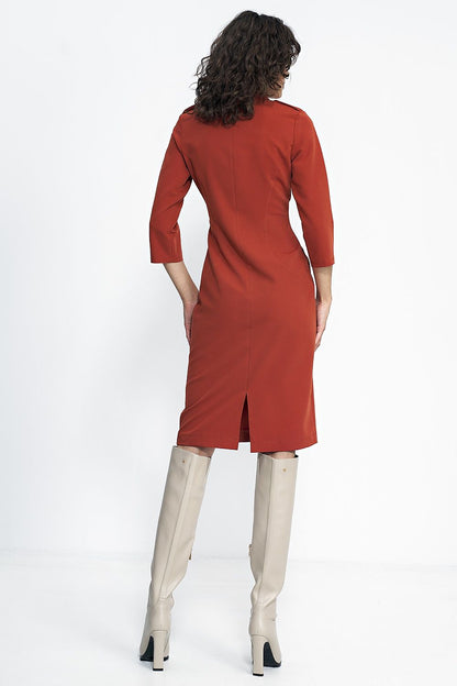 Elegant Nife Daydress styled with long boots, showcasing its tailored fit and sophisticated look, ideal for colder days in autumn.
