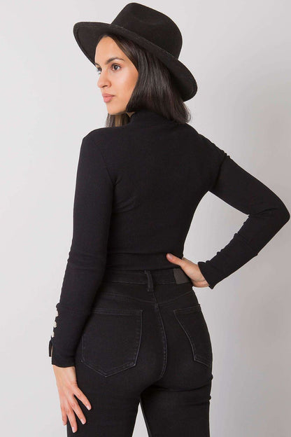 Model wearing Rue Paris's elegant fitted blouse with ribbed fabric, styled for a chic and elegant daytime look.