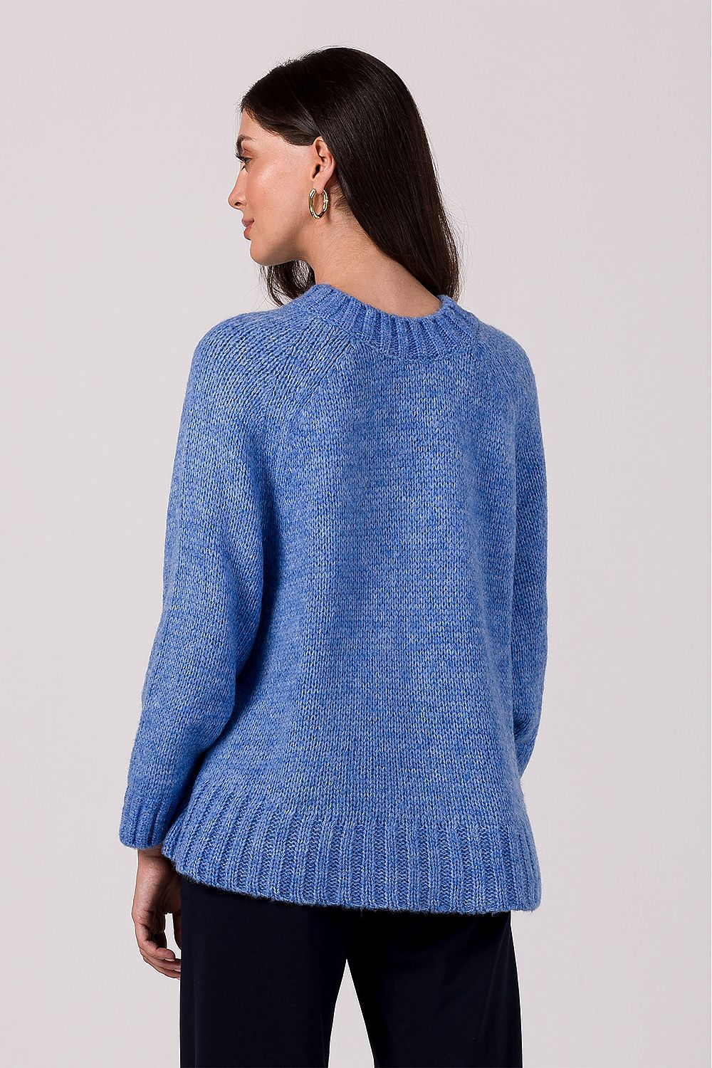 Detail of the ribbed edges and batwing sleeves of a luxurious women's knit jumper, highlighting the comfort and unique character of the piece.