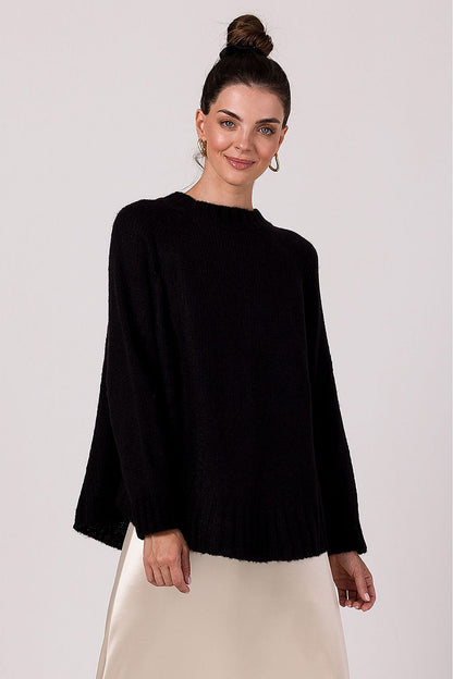 Fashionable women's oversized knit sweater in ribbed yarn, styled against a minimalist backdrop, showcasing its charm and comfort for colder days.