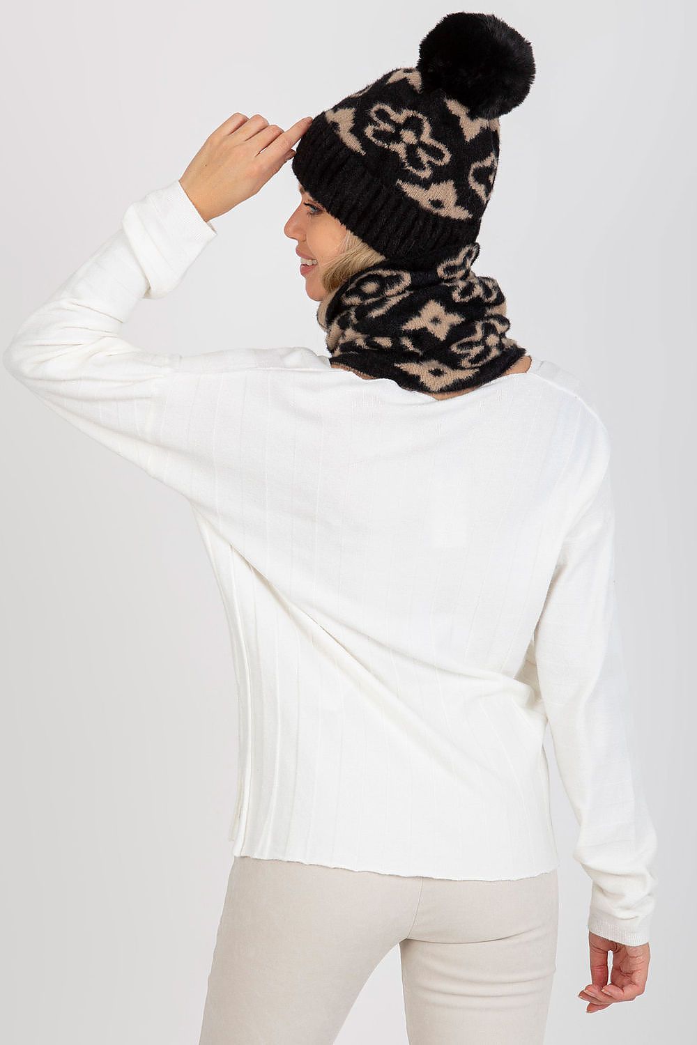 Elegant winter cap with prominent pom-pom and wide welt, made from 100% acrylic for premium comfort and style.