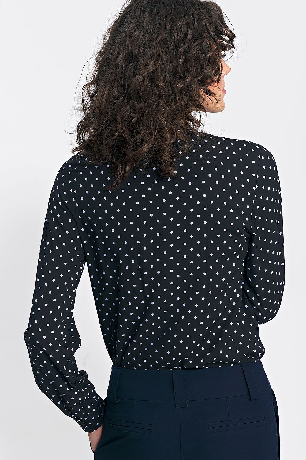 The elegant long sleeve button-down shirt by Nife displayed on a hanger, showcasing its refined cut and fashionable design suitable for autumn styling.